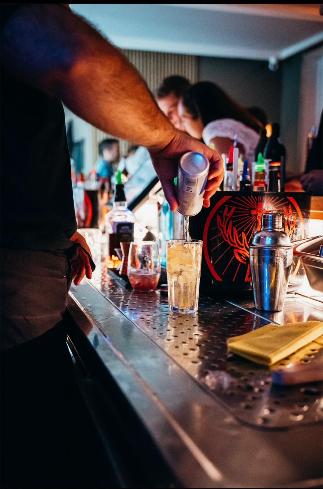 Barkeeper füllt einen Longdrink auf
