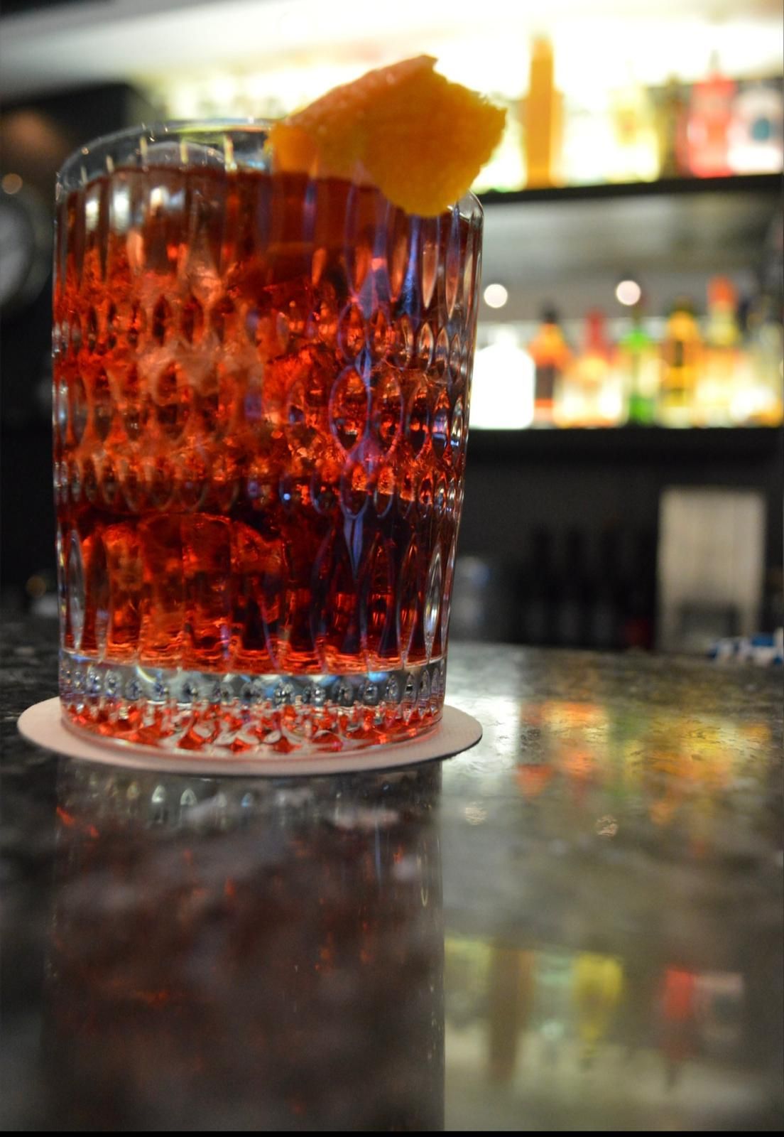 Negroni mit Orangenzeste auf dem Tresen